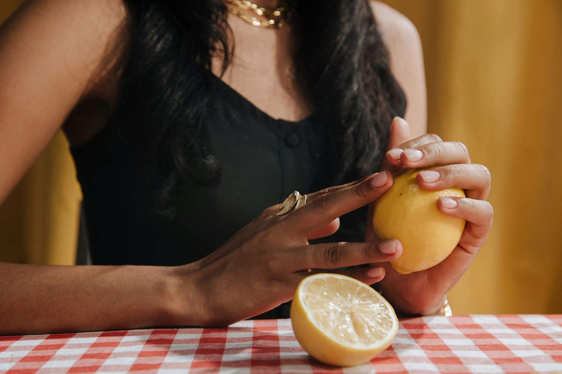 Close-up of a woman holding a fresh lemon, representing sensitivity and natural pleasure intensity.