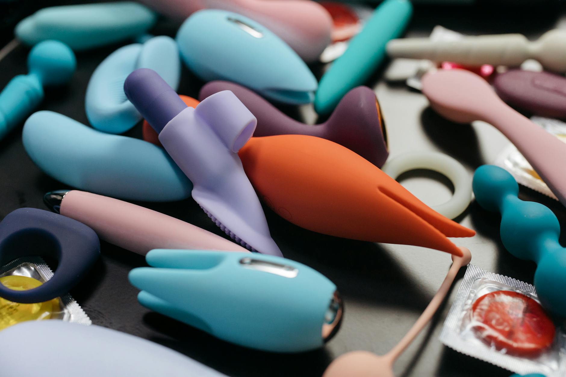 A sleek blue silicone vibrator held in hand against a solid purple background, promoting self-love during hormonal transitions.