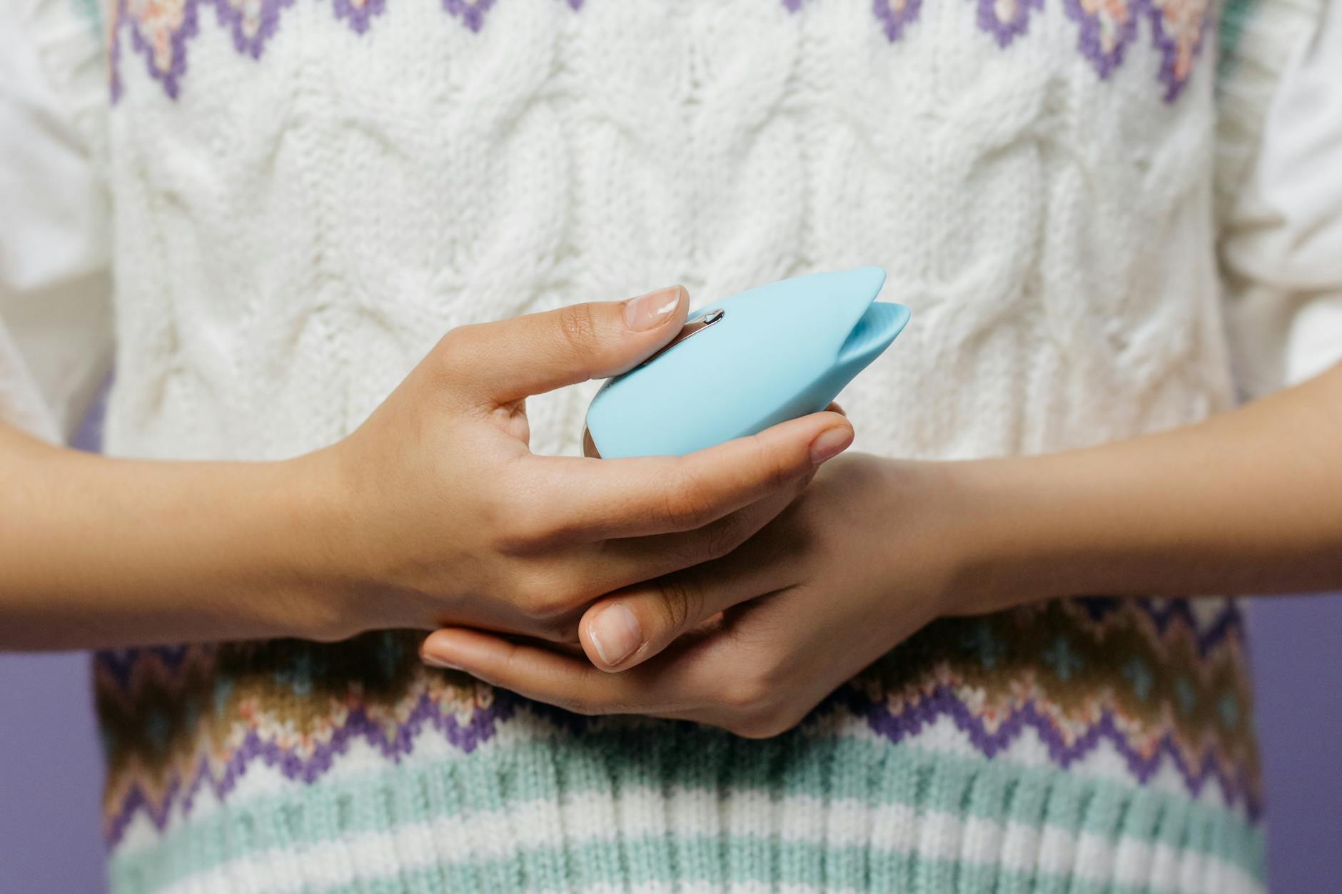 Woman holding clitoral vibrators in contemplation